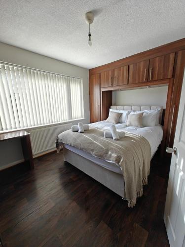 a bedroom with a large bed with white pillows at Under 10 Mins to NEC BHX - Walk to JLR -2 Large Living Areas - 4 Bedroom Spacious Home - Van Parking x2 - 5 Beds Excellent Equipped Home - NR A45 Solihull Bypass M42 HS2 Works in Solihull