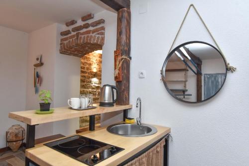 een badkamer met een wastafel en een spiegel aan de muur bij Guest House Amfora in Budva