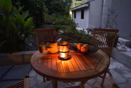 een houten tafel met een kaars en een fruitschaal bij Guest House Amfora in Budva