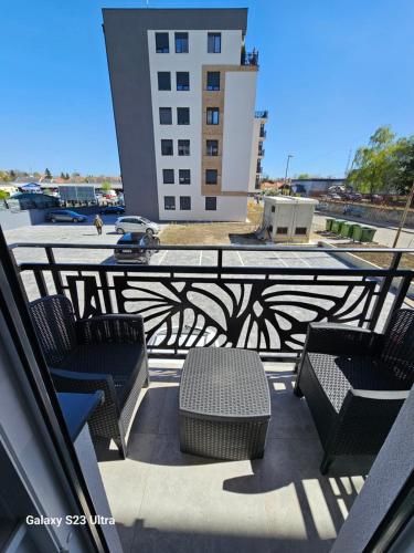 a balcony with chairs and a table and a building at Apartman Lena in Zrenjanin