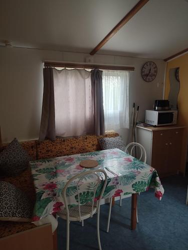 un salon avec une table et un canapé dans l'établissement Mobil home a ste croix du verdon camping 3, à Sainte-Croix-de-Verdon