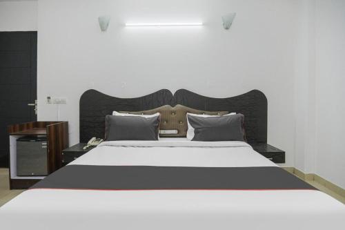 1 dormitorio con 1 cama grande y cabecero de madera en StayKar by Loomstay en Gurgaon