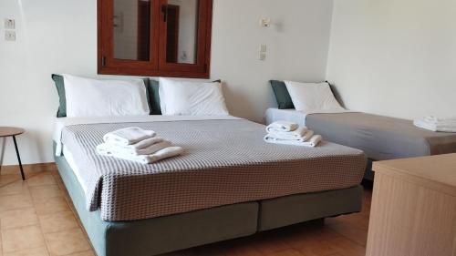 two beds in a room with towels on them at Maria Apartments in Pefki