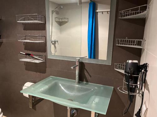 a bathroom with a green sink and a mirror at Appart Duplex Roses Plage in Roses