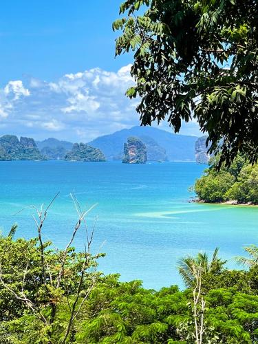 a view of a large body of water with mountains at Hillhouse - Koh Yao Noi in Ko Yao Noi