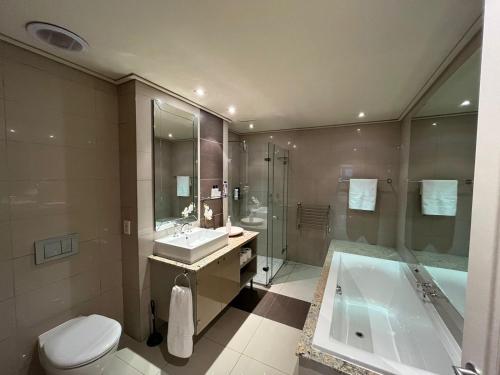 y baño con aseo, lavabo y bañera. en Cape Royale Luxury Suite, en Ciudad del Cabo