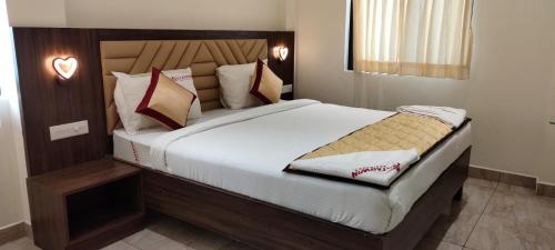 ein Schlafzimmer mit einem großen Bett mit weißer Bettwäsche und Kissen in der Unterkunft Starwin Residency in Ramanathapuram