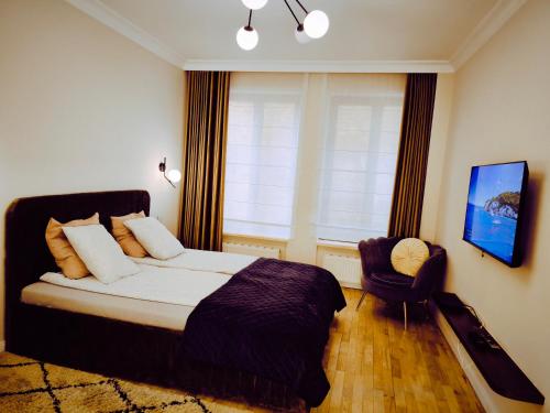 a bedroom with a bed and a chair and a window at Central Apartments Ogarna 5 in Gdańsk