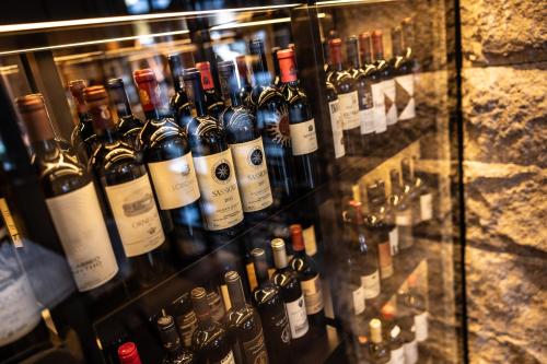 a display case filled with lots of bottles of wine at Savoy Dolomites Luxury & Spa Hotel in Selva di Val Gardena