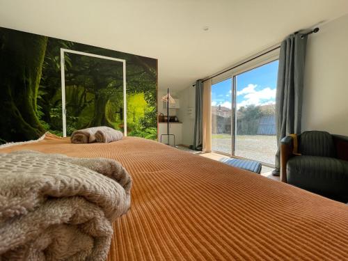 una camera da letto con un grande letto con una grande finestra di RELAI DU CHATEAU APPARTHOTEL a La Tourlandry