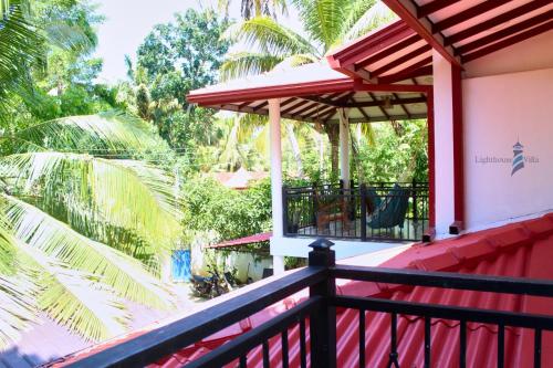 a balcony of a house with a red roof at Lighthouse Villa Koggala in Galle