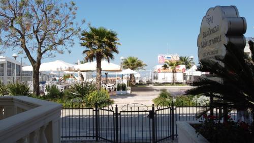 uma vista para um resort com uma cerca de ferro forjado em Residenza Mediterranea Apartments em Rimini