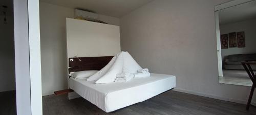 a bedroom with a bed with white pillows and a mirror at Casa Guarnati Lake View Apartments in Malcesine