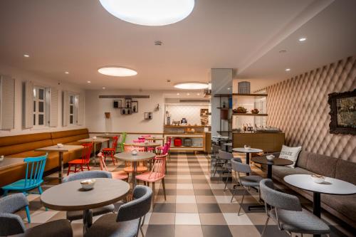 un restaurant avec des tables et des chaises et une cuisine dans l'établissement Embassy Hotel Tel Aviv, à Tel Aviv