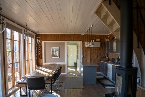 a kitchen with a wooden ceiling and a dining table at Klara House in Isfjorden