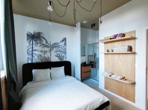 1 dormitorio con 1 cama con un mural de palmeras en la pared en L'appart by Authentic en Saint-Ghislain
