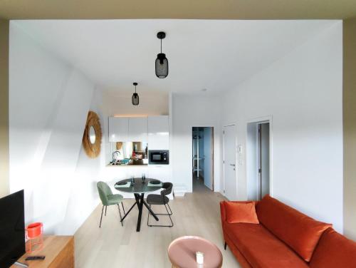 ein Wohnzimmer mit einem Sofa und einem Tisch in der Unterkunft L'appart by Authentic in Saint-Ghislain
