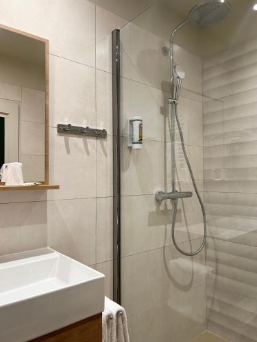 une salle de bain avec douche et lavabo dans l'établissement Hôtel du Musée, à Arles