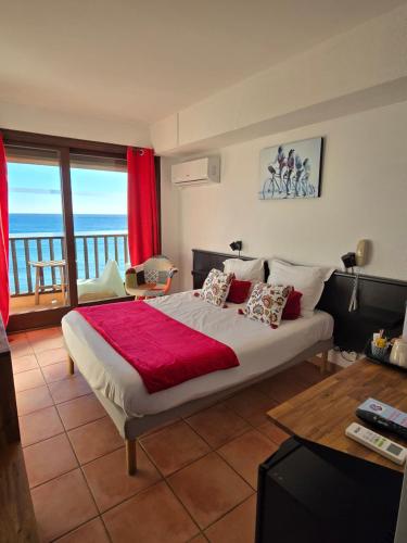 Schlafzimmer mit einem Bett und Meerblick in der Unterkunft Hotel Chanteplage in Saint-Cyr-sur-Mer