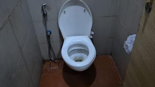 uma casa de banho com um WC branco numa cabina em Hours home em Calcutá