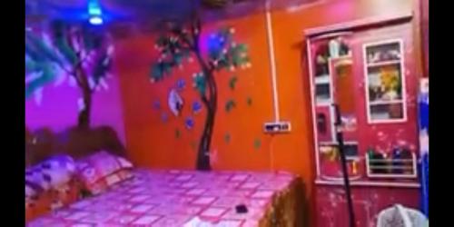 a bedroom with a bed and trees painted on the wall at Hours home in Kolkata