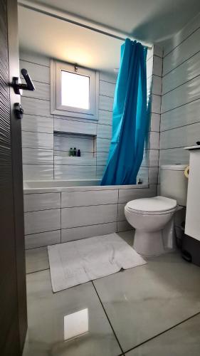 a bathroom with a toilet and a blue shower curtain at 351 Turquoise Oasis in Limassol