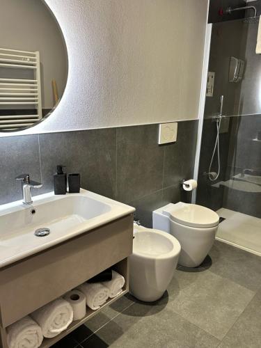 a bathroom with a sink and a toilet and a mirror at Civico 29 rooms in Peschiera del Garda