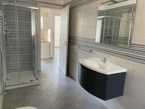 y baño con lavabo, espejo y ducha. en Casa vacanze Marinella en Bagnara Calabra