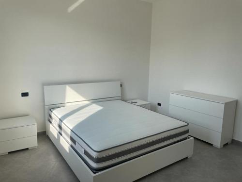 1 dormitorio blanco con 1 cama y 2 mesitas de noche en Casa vacanze Marinella en Bagnara Calabra