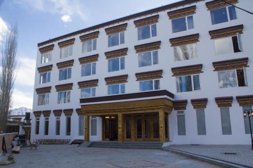 Biały budynek ze złotą ozdobą w obiekcie Hotel Dekiling by Ladakh lodge Group w mieście Leh
