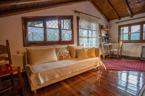 a living room with a couch and some windows at Alonia Forest House in Kryonérion