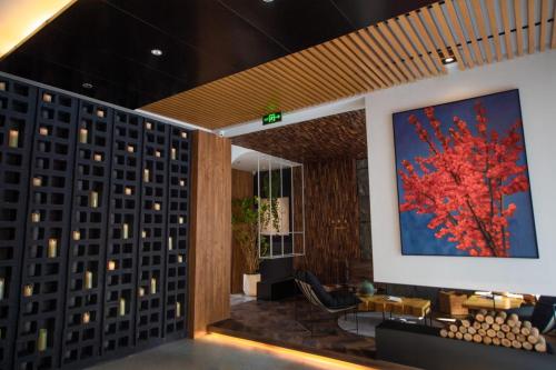 a lobby with a painting of a red tree at Yiwu Holly Hotel in Yiwu