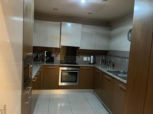 a kitchen with wooden cabinets and a stove top oven at Cape Royale Luxury Suite in Cape Town