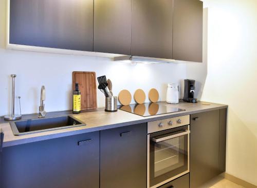 cocina con fregadero y encimera en Modernes Apartment l Oasis l mit Balkon Nähe Hauptbahnhof, en Essen
