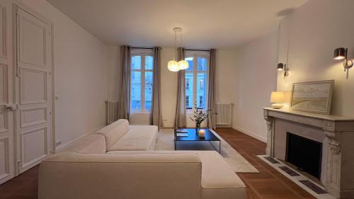ein Wohnzimmer mit einer weißen Couch und einem Kamin in der Unterkunft Appartement standing coeur de Vendôme Caroline Paul Officiel in Vendôme