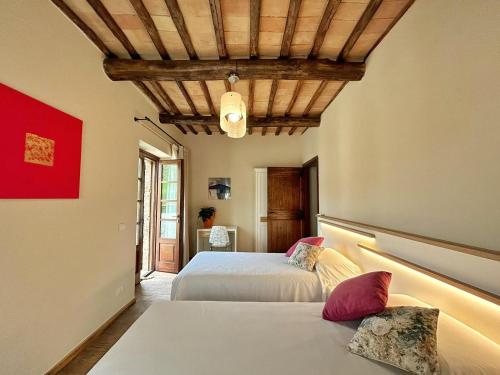 una camera con 2 letti e un soffitto in legno di CasalPiano a Orvieto