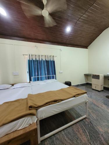 a bed in a room with a ceiling fan at The Stone Cabin Cottage in Gokarna