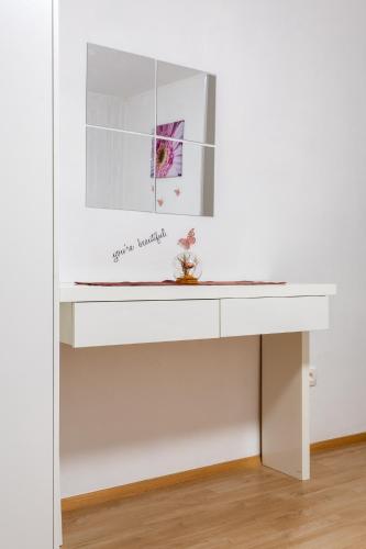 a white desk in a white room with a flower on it at Apartma Lozar in Ajdovščina
