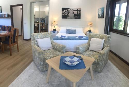 a bedroom with a bed and two chairs and a table at Magic Oak Getaway in Marysville