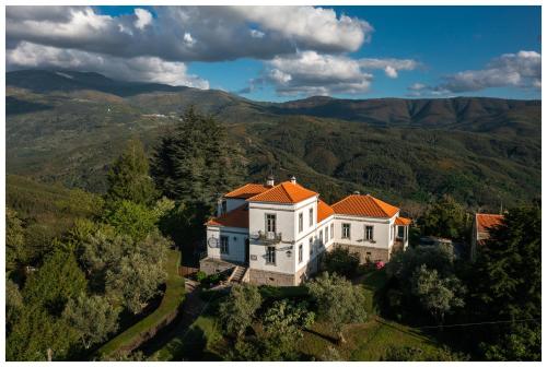an aerial view of a house with mountains in the background at Alojamento Estrela Cottage in Torrozelo