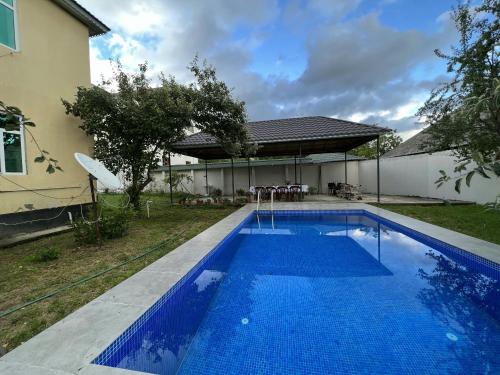 a blue swimming pool in front of a house at Villa at the center in Gabala