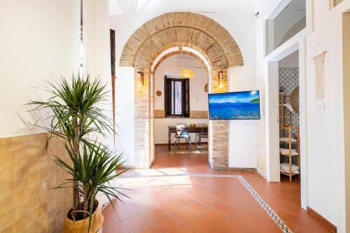 a hallway with an archway in a house with plants at BOHEMIAN - Taormina Central Apartment in Taormina