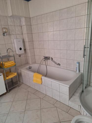 W łazience znajduje się wanna z prysznicem i umywalka. w obiekcie Eleni w mieście Emden