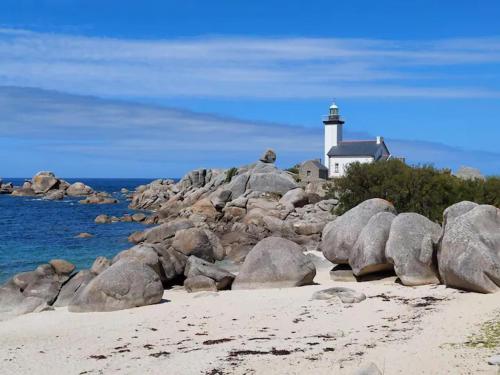 un phare sur la rive d'une île rocheuse dans l'établissement Villa les pieds dans l'eau, vue mer imprenable, à Plounéour-Trez