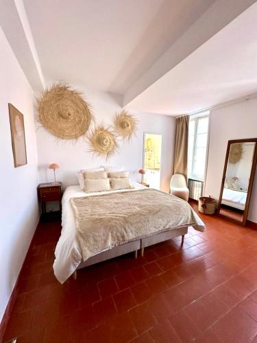 - une chambre avec un grand lit et deux paniers sur le mur dans l'établissement Grande Maison familiale Leucate Village, à Leucate
