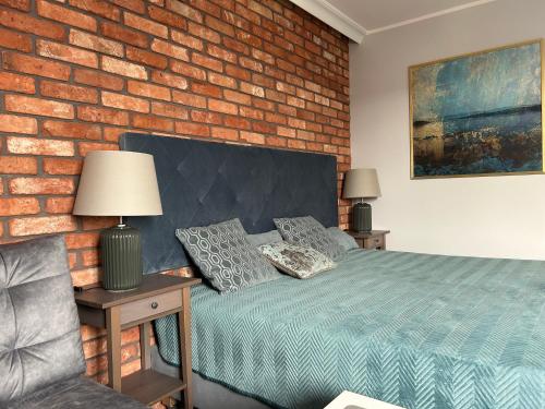 a bedroom with a bed and a brick wall at Apartament Anna in Sopot