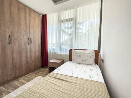 a small bedroom with a bed and a window at 111-Luxury Concept Family House in Ankara