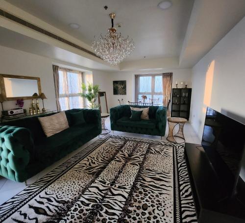 een woonkamer met twee groene banken en een tapijt bij Luxury stay in Marina in Dubai