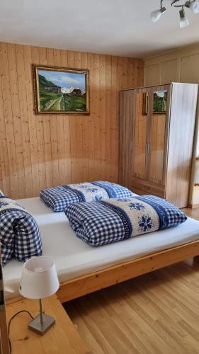 a bedroom with two beds with blue and white pillows at Pension Hof zur Stilli in Davos