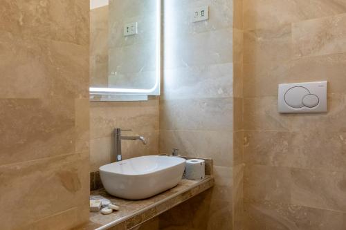 a bathroom with a white sink and a mirror at Via del Corso Roma Luxury Suite in Rome